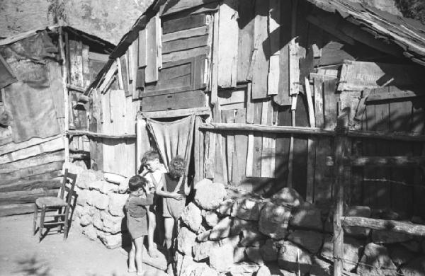 Italia Dopoguerra: Valmontone bombardata. Valmontone - Baracca - Ritratto di gruppo: bambini sulla soglia di una baracca