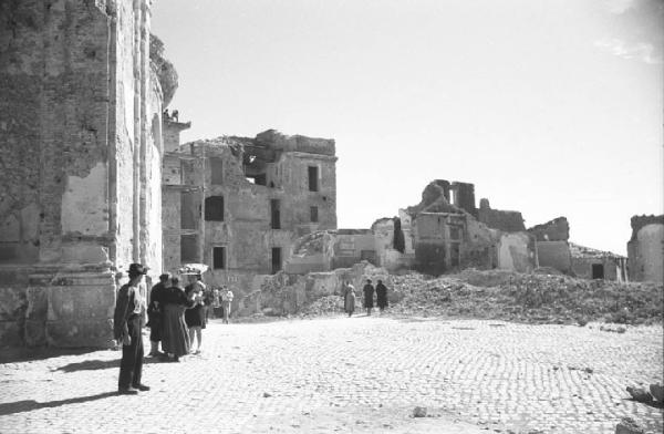 Italia Dopoguerra: Valmontone bombardata. Valmontone - Persone in piazza con edifici bombardati e macerie