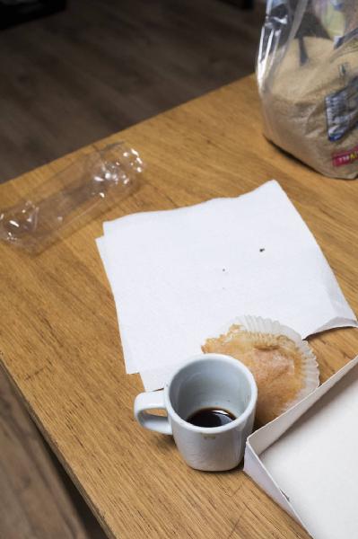 Check in': Wood's House. Torino - Abitazione: interno - Tavolo - Tazzina con caffè - Carta di merendina - Busta di plastica con zucchero di canna - Tovagliolo di carta - Bustina di plastica - Angolo di una scatola