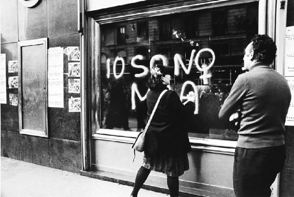 Io sono mia. Milano - Strada - Ritratto femminile: donna scrive con bomboletta "Io sono mia"