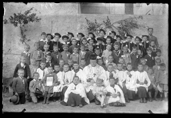 Gruppo di bambini con parroco e chierichetti