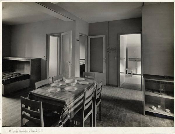 V Triennale - Mostra dell'abitazione - Gruppo di elementi di case popolari di Enrico Griffini e Piero Bottoni - Stanza di soggiorno-letto di un alloggio tipo di 35,50 mq.