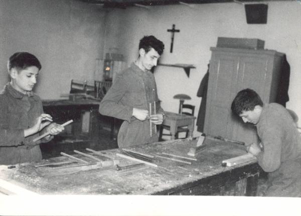 Istituto dei Ciechi di Milano - Scuola di avviamento professionale - Laboratorio di falegnameria - Interno - Allievi lavorano il legno intorno a un tavolo