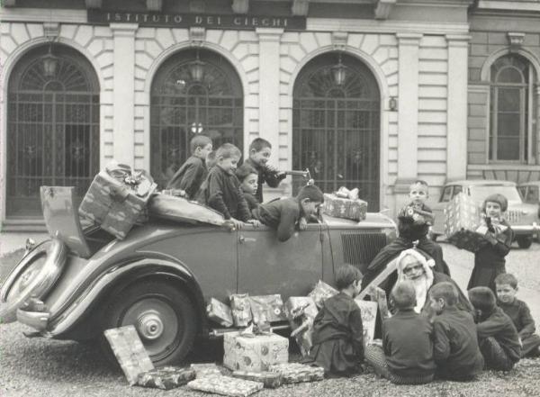 Istituto dei Ciechi di Milano - Cortile davanti all'ingresso - Babbo Natale con auto cabriolet - Bambini - Regali