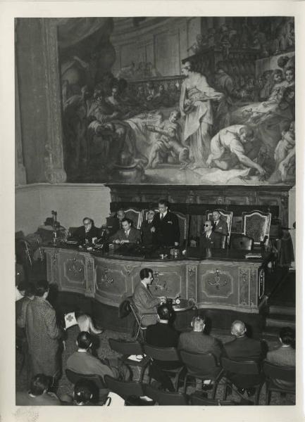 Convegno dell'Unione Italiana Ciechi - Interno - Tavolo della presidenza con relatori, in seconda fila Virginio Pozzi Presidente dell'Istituto dei Ciechi di Milano - Affresco