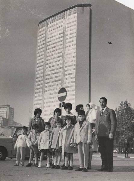 Milano - Piazza Duca d'Aosta - Ritratto di famiglia - Operaio con moglie e dieci figli davanti al grattacielo Pirelli