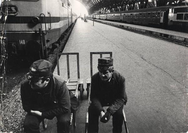 Milano - Stazione Centrale - Interno - Sciopero dei treni - Banchina dei treni deserta - Facchini portabagagli seduti sul carrello