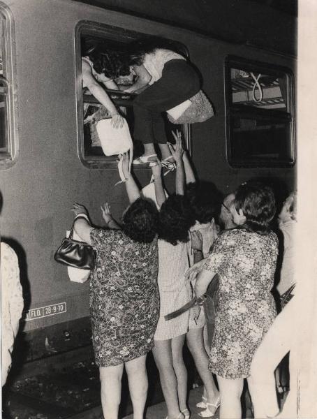 Milano - Stazione Centrale - Partenze per le vacanze estive - Banchina - Salita sul treno - Ragazze si arrampica dal finestrino