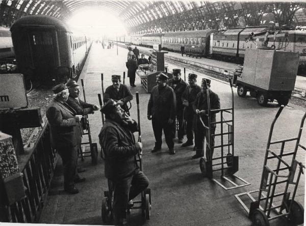 Milano - Stazione Centrale - Interno - Sciopero dei treni - Banchina dei treni deserta - Facchini portabagagli in riposo