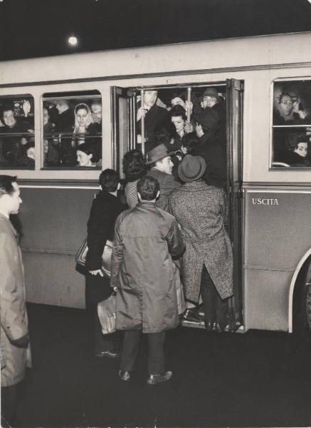Milano - Fermata Atm - Folla cerca di salire sull'autobus strapieno