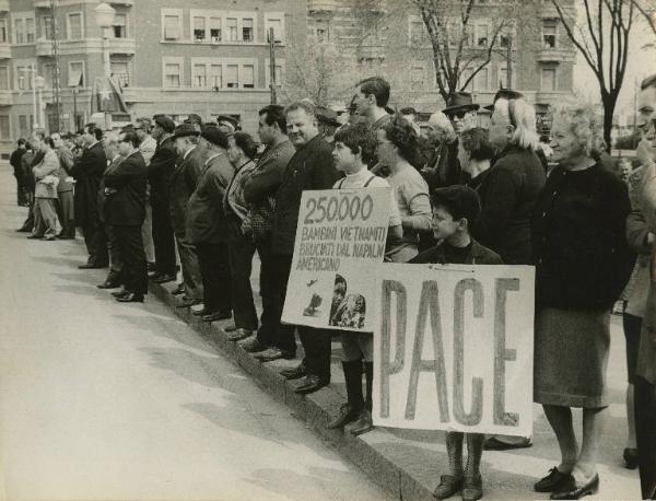 Milano - Piazza Miani - Manifestazione per il Vietnam - Cittadini schierati sul marciapiede - Cartelli