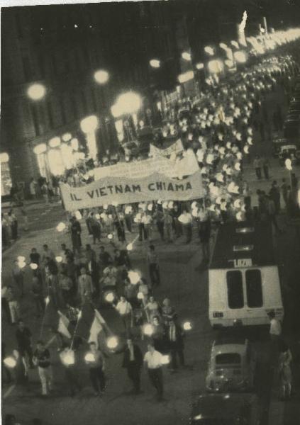 Milano - Manifestazione per il Vietnam - Corteo notturno di cittadini recanti torce accese - Striscione - Automobili