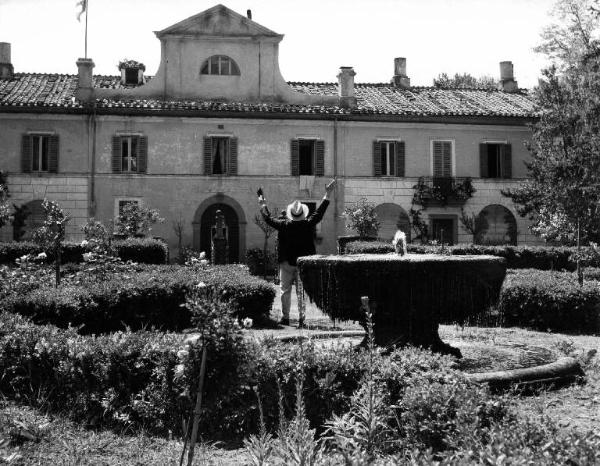 Scena del film "Il padrone sono me" - Regia Franco Brusati - 1955 - Attore non identificato di schiena in un giardino