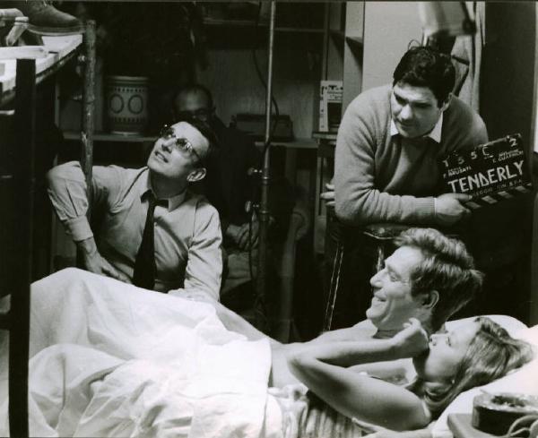 Set del film "Tenderly" - Regia Franco Brusati - 1968 - Gli attori Virna Lisi e George Segal a letto sotto le lenzuola e il regista Franco Brusati