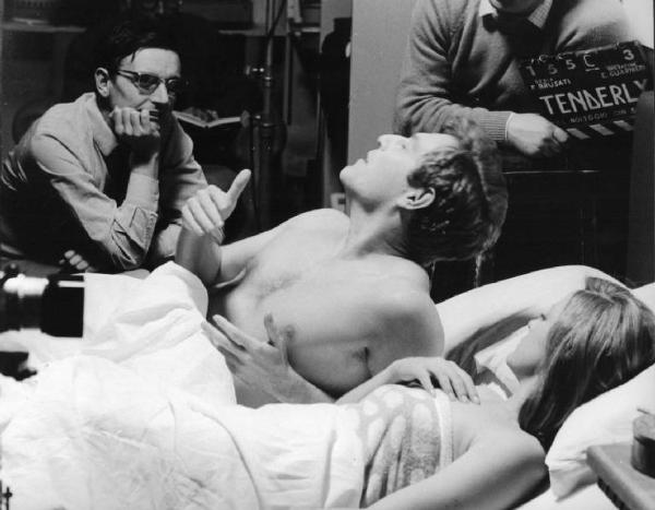 Set del film "Tenderly" - Regia Franco Brusati - 1968 - Gli attori Virna Lisi e George Segal a letto e il regista Franco Brusati durante le riprese del film.