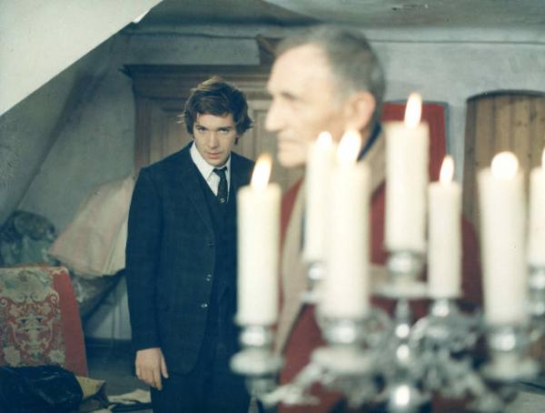 Scena del film "I tulipani di Haarlem" - Regia Franco Brusati - 1970 - In primo piano un attore non identificato e un candelabro. Sullo sfondo l'attore Frank Grimes