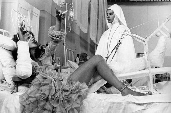 Scena del film "Bianco, rosso e..." - Regia Alberto Lattuada - 1972 - L'attrice Sophia Loren in abito da suora e l'attrice Tina Aumont sul letto di un ospedale