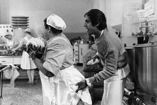 Scena del film "Bianco, rosso e..." - Regia Alberto Lattuada - 1972 - L'attore Adriano Celentano in una cucina con attrici non identificate