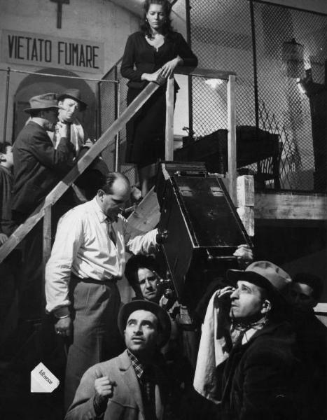 Set del film "La lupa" - Regia Alberto Lattuada - 1953 - Il regista Alberto Lattuada sul set con il direttore della fotografia Aldo Tonti e degli operatori, alcuni attori non identificati e l'attrice Kerima in cima a una scala