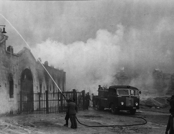 Scena del film "La lupa" - Regia Alberto Lattuada - 1953 - Un vigile del fuoco doma un incedio di un palazzo