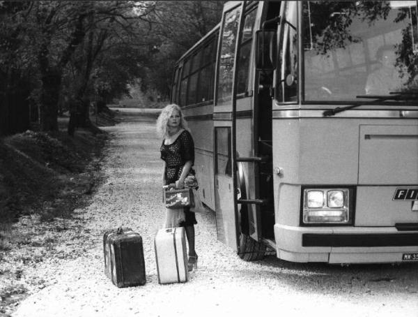 Scena del film "La cicala" - Regia Alberto Lattuada - 1980 - L'attrice Virna Lisi con valige accanto a un pullman