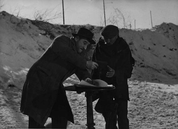 Scena del film "Il cappotto" - Regia Alberto Lattuada - 1952 - L'attore Renato Rascel intento a scrivere e un attore non identificato