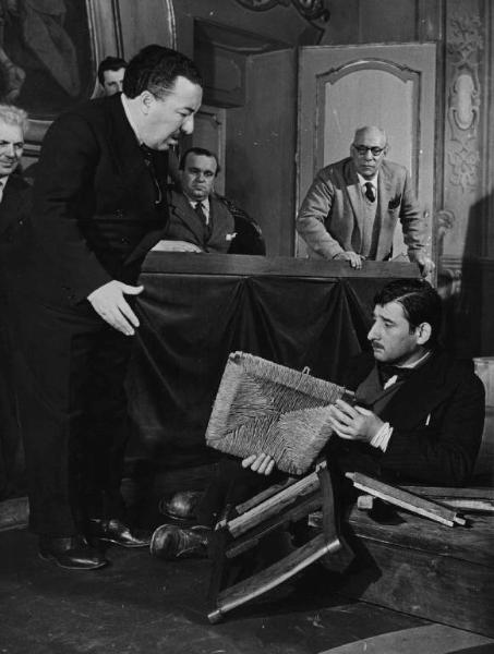 Scena del film "Il cappotto" - Regia Alberto Lattuada - 1952 - L'attore Renato Rascel a terra con una sedia rotta ossrvato dagli attori Ettore G. Mattia, Mimmo Poli e tre attori non identificati