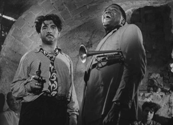 Scena del film "Luci del varietà" - Regia Alberto Lattuada, Federico Fellini - 1950 - L'attore John Kitzmiller con la tromba e un attore non identificato con la pistola