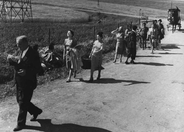 Scena del film "Luci del varietà" - Regia Alberto Lattuada, Federico Fellini - 1950 - Gli attori Peppino De Filippo, Giulietta Masina, Carla Del Poggio e Dante Maggio per strada con attori non identificati seguiti da una carrozza