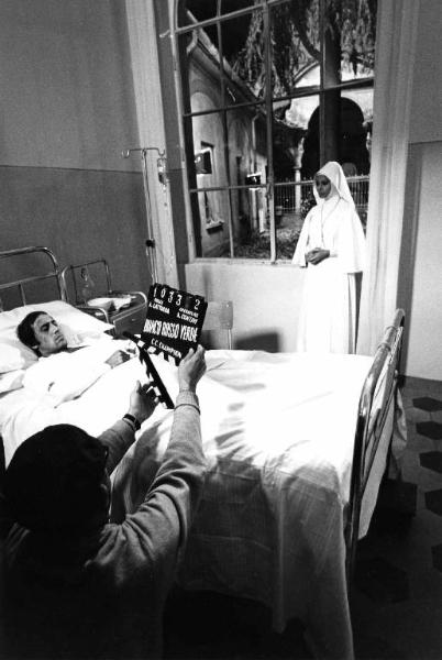 Set del film "Bianco, rosso e..." - Regia Alberto Lattuada - 1972 - Il regista Alberto Lattuada sul set con gli attori Adriano Celentano, a letto in ospedale, e Sophia Loren in abito da suora