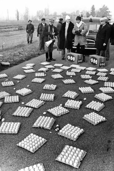 Set del film "Bianco, rosso e..." - Regia Alberto Lattuada - 1972 - Il regista Alberto Lattuada sul set con degli operatori su una strada piena di uova