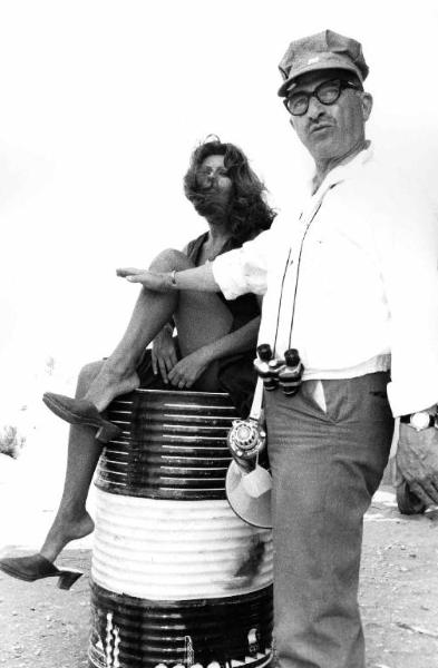 Set del film "Bianco, rosso e..." - Regia Alberto Lattuada - 1972 - Il regista Alberto Lattuada sul set con l'attrice Sophia Loren seduta su un bidone