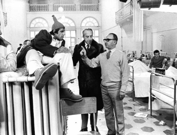 Set del film "Bianco, rosso e..." - Regia Alberto Lattuada - 1972 - Il regista Alberto Lattuada e l'attore Adriano Celentano sul set in ospedale