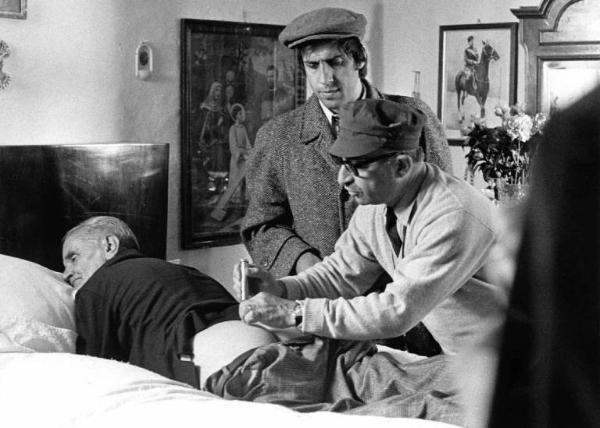 Set del film "Bianco, rosso e..." - Regia Alberto Lattuada - 1972 - Il regista Alberto Lattuada con l'attore Adriano Celentano e un'attore non identificato sul letto