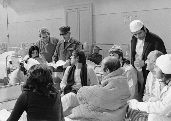 Set del film "Bianco, rosso e..." - Regia Alberto Lattuada - 1972 - Il regista Alberto Lattuada sul set con gli attori Enzo Cannavale, Adriano Celentano e attori non identificati in ospedale