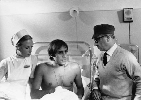 Set del film "Bianco, rosso e..." - Regia Alberto Lattuada - 1972 - Il regista Alberto Lattuada sul set con l'attore Adriano Celentano e un'attrice non identificata in ospedale