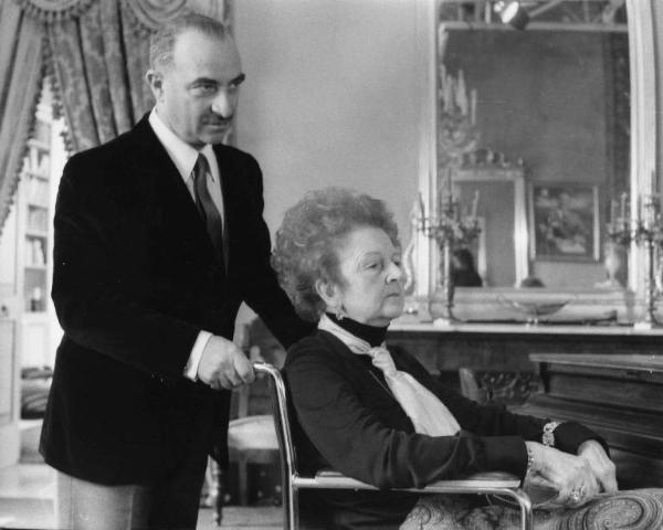 Set del film "Le farò da padre" - Regia Alberto Lattuada - 1974 - Il regista Alberto Lattuada e un'attrice non identificata su una sedia a ruote