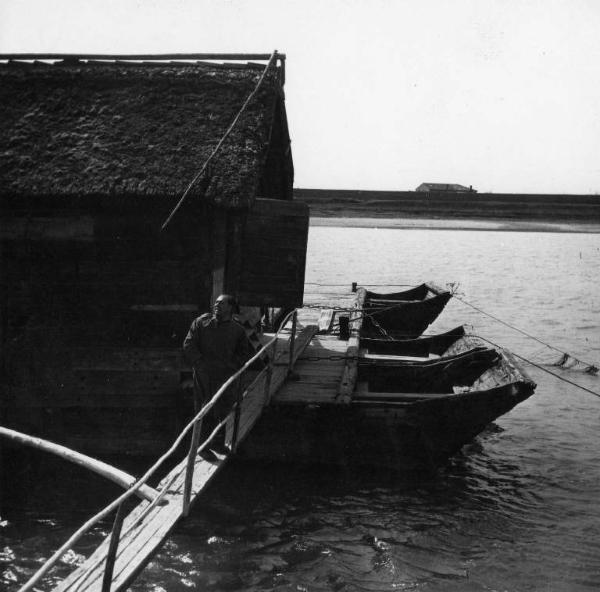 Scena del film "Il mulino del Po" - Regia Alberto Lattuada - 1948 - Un attore non identificato su un ponticello che conduce a una capanna sul fiume Po