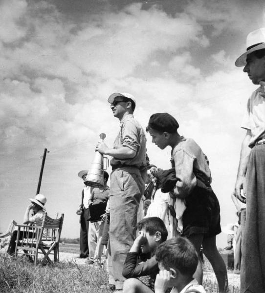 Set del film "Il mulino del Po" - Regia Alberto Lattuada - 1948 - Il regista Alberto Lattuada sul set con un megafano e dei bambini attorno