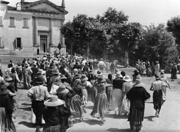 Scena del film "Il mulino del Po" - Regia Alberto Lattuada - 1948 - Una folla di persone si dirige verso una chiesa