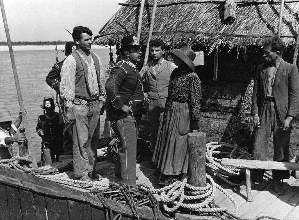 Scena del film "Il mulino del Po" - Regia Alberto Lattuada - 1948 - L'attore Giacomo Giuradei e attori non identificati su una capanna sul fiume Po