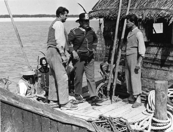 Scena del film "Il mulino del Po" - Regia Alberto Lattuada - 1948 - L'attore Giacomo Giuradei e attori non identificati su una capanna sul fiume Po