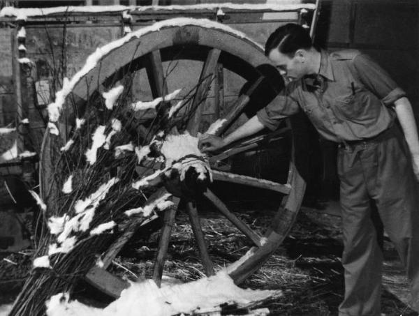 Scena del film "Giacomo l'idealista" - Regia Alberto Lattuada - 1943 - Un operatore sul set accanto a una ruota di un carro