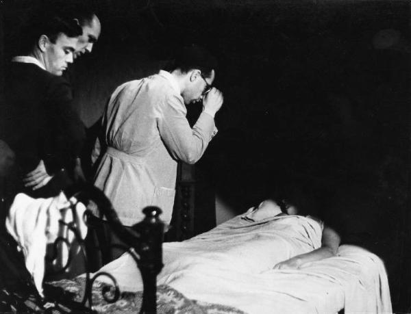 Set del film "Giacomo l'idealista" - Regia Alberto Lattuada - 1943 - Il regista Alberto Lattuada con due operatori e l'attrice Marina Berti a letto