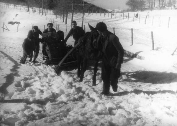 Set del film "Giacomo l'idealista" - Regia Alberto Lattuada - 1943 - Il regista Alberto Lattuada e alcuni operatori trasportano gli attrezzi con su un carretto trainato da un asino