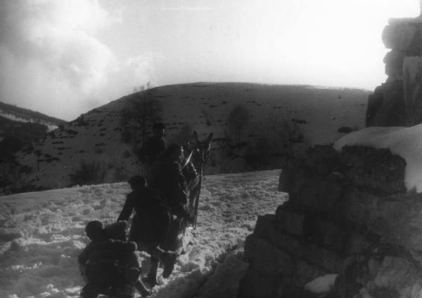 Scena del film "Giacomo l'idealista" - Regia Alberto Lattuada - 1943 - L'attrice Marina Berti su un carretto trainato da un asino su una strada innevata di montagna seguita da due bambini e con un attore non identificato