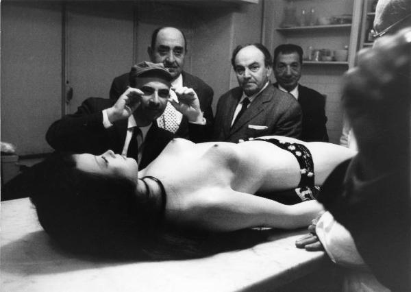 Set del film "Don Giovanni in Sicilia" - Regia Alberto Lattuada - 1967 - Il regista Alberto Lattuada e gli operatori osservano il manichino di una donna nuda stesa sul tavolo