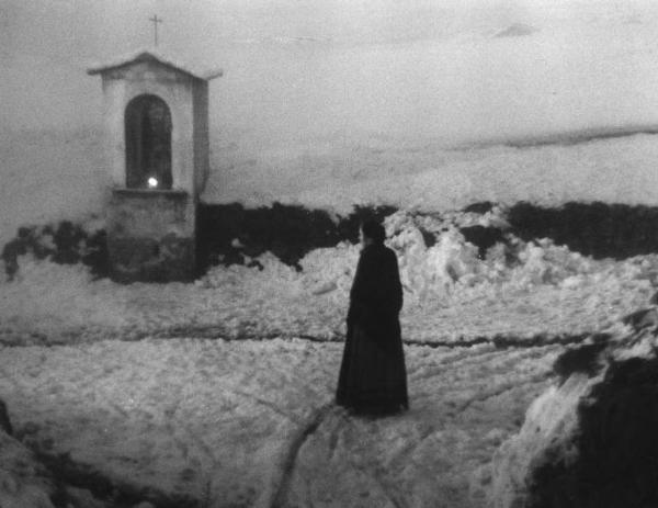 Scena del film "Giacomo l'idealista" - Regia Alberto Lattuada - 1943 - L'attrice Marina Berti sulla neve davanti a un'edicola sacra