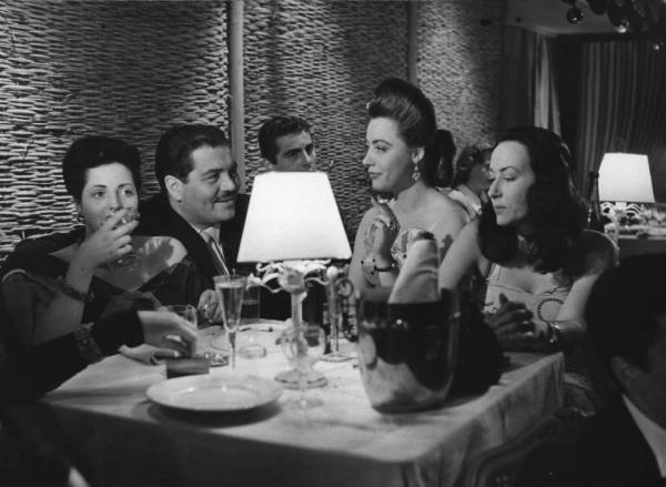 Scena del film "Luci del varietà" - Regia Alberto Lattuada, Federico Fellini - 1950 - L'attore Folco Lulli al ristorante a tavola con tre attrici non identificate