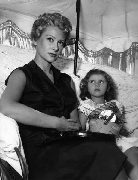 Scena del film "La spiaggia" - Regia Alberto Lattuada - 1953 - L'attrice Martine Carol con una bambina sotto l'ombrellone